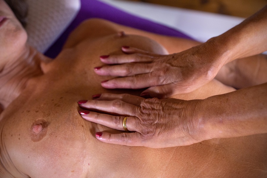 Yvonne massages a naked lady's breasts